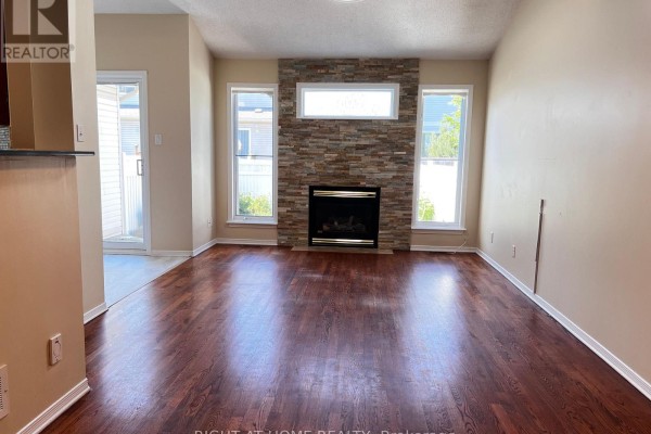 Interior hallway with dark wood floor, staircase with carpeted treads, and white doors. - 1741 Jobin Crescent, Ottawa
