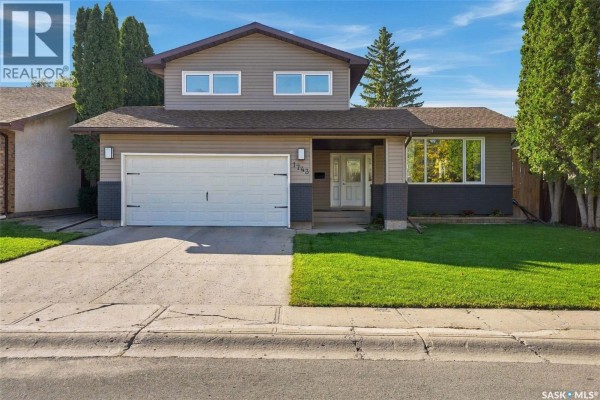 Front exterior of a two-story house with beige and dark grey siding. - 1743 Blair Bay E, Regina