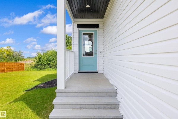 Close-up of the front porch with light blue door and steps leading up. - 17431 7 St Ne, Edmonton