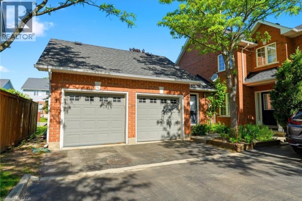 Living room with hardwood floors, fireplace, and large windows with curtains. - 1745 Creek Way Unit# 7, Burlington