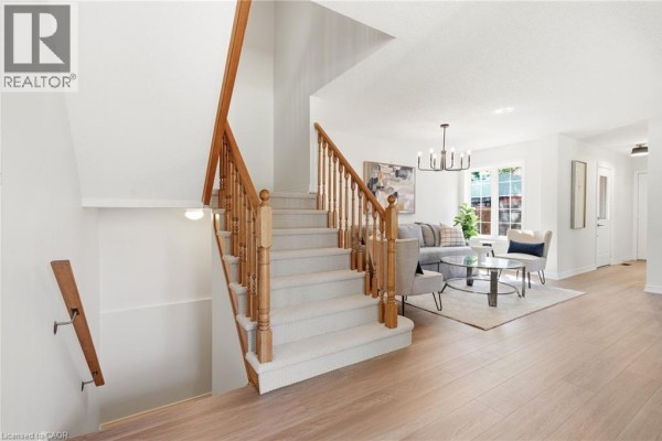 Kitchen with wood cabinets, tiled backsplash, stainless steel refrigerator, and black stove. - 1745 Creek Way Unit# 7, Burlington