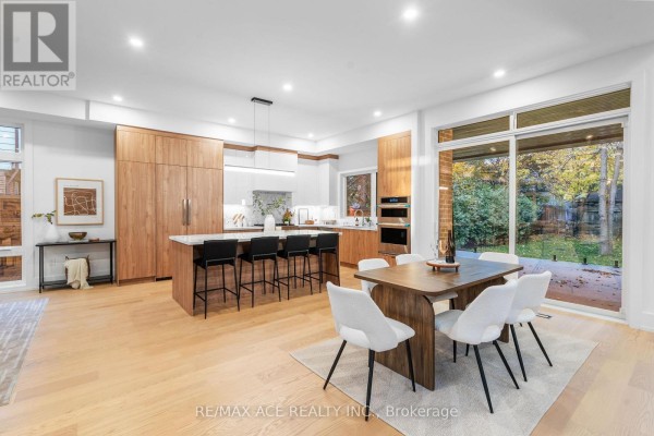 Modern kitchen with island, dining area, and backyard view - 175 Harewood Avenue Toronto