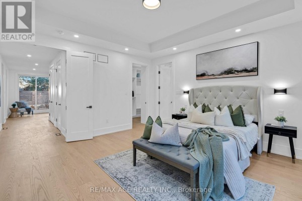 Modern bedroom with tufted headboard, artwork, bench, and walk-in closet - 175 Harewood Avenue Toronto