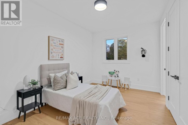 Bedroom with white walls, wood floors, and a queen bed - 175 Harewood Avenue Toronto