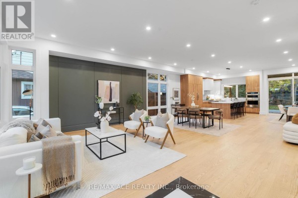 Spacious living area overlooking the kitchen and dining space with light wood floors. - 175 Harewood Avenue, Toronto