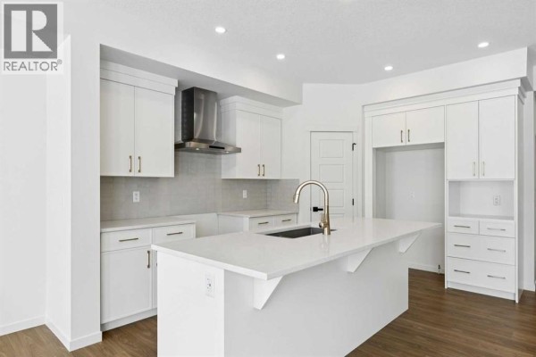 Kitchen with white cabinets, stainless steel appliances, and a central island. - 175 Herron Landing Ne, Calgary
