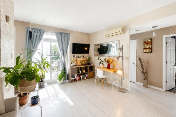 Living room with light wood floors, blue curtains, and a desk. - 175 Rue De La Fabrique, #2, Gatineau