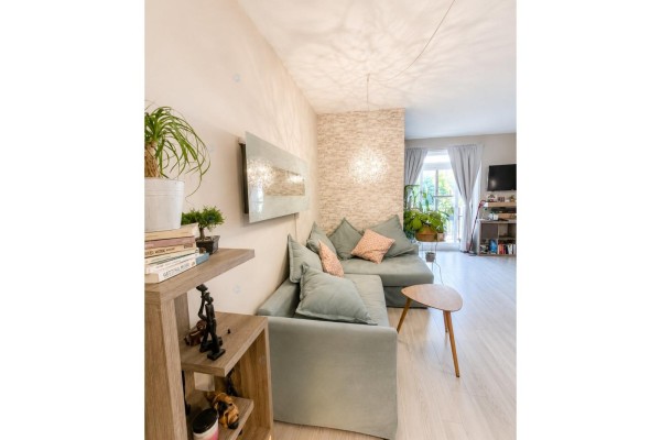 Living room with light wood floors, a grey sectional sofa, and decorative wall. - 175 Rue De La Fabrique, #2, Gatineau