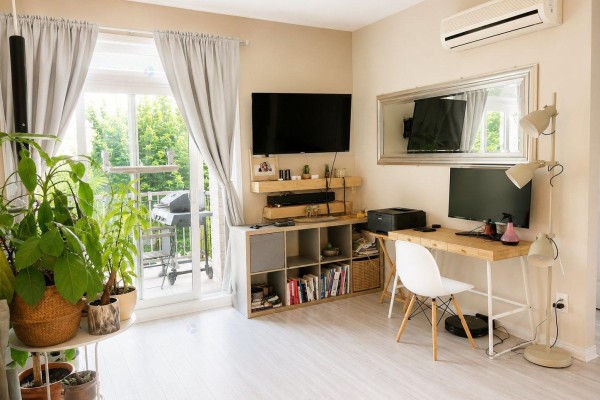 Living room with light wood floors, desk, television, and balcony access. - 175 Rue De La Fabrique, #2, Gatineau