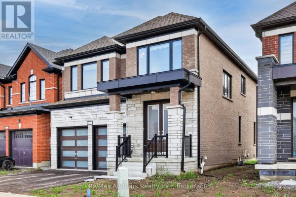 A residential house with brick and stone exterior, two garage doors, and contemporary windows under a cloudy sky. - 175 St. Joseph Road, Kawartha Lakes