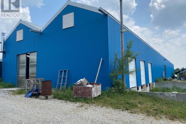 Close-up of a blue industrial building with large bay doors and corrugated metal siding. - 1753 Windham 9 Road, Norfolk