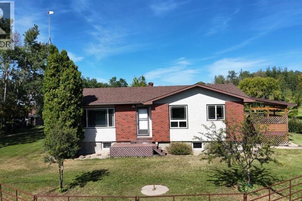 Exterior front view of a light brick and white house with a covered porch. - 17530 Township Road 763a, Rural Big Lakes County