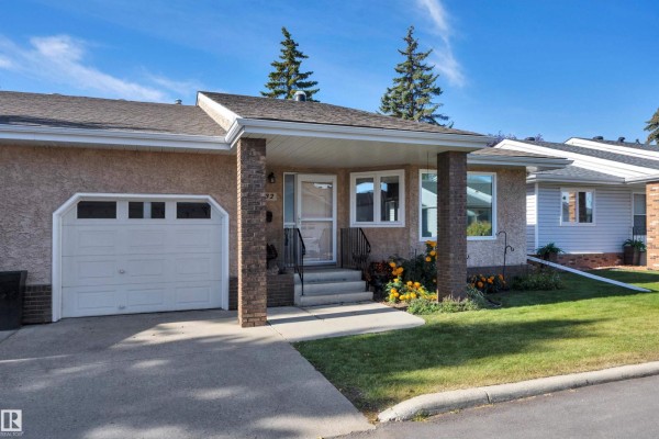 Close-up of entrance with snow, showing front steps and large window. - 17532 Callingwood Rd Nw, Edmonton