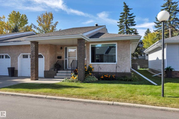Side view of duplex highlighting snow-covered roof and large window. - 17532 Callingwood Rd Nw, Edmonton
