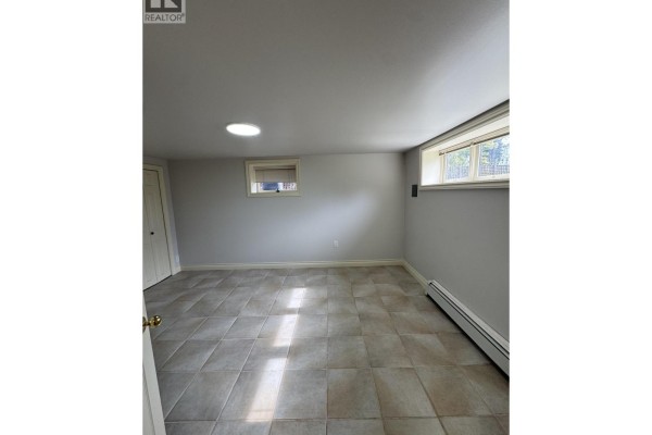 Unfurnished room with tiled floor, light gray walls, a closet, and two windows. - 1758b Western Parkway, Vancouver