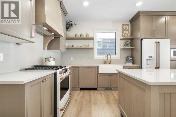 Kitchen featuring a large island, ample storage, appliances, and pendant lighting with vaulted ceiling. - 176, 27111 Highway 597 Road, Rural Lacombe County