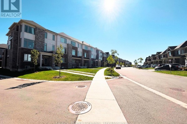 Street view of a townhouse development with paved road and sidewalk, lined with homes. - 176 Lageer Drive, Whitchurch Stouffville