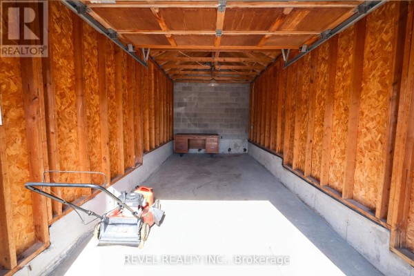 Garage with mower and desk - 176 Towerhill Road Peterborough