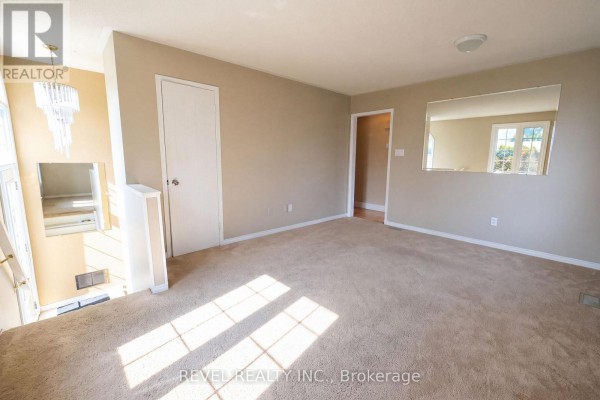 Living room with beige carpet, neutral walls, and large mirror. - 176 Towerhill Road, Peterborough