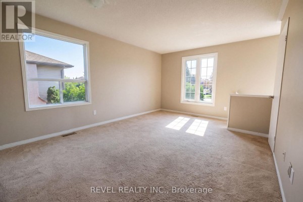 Bedroom with beige walls and two windows - 176 Towerhill Road Peterborough