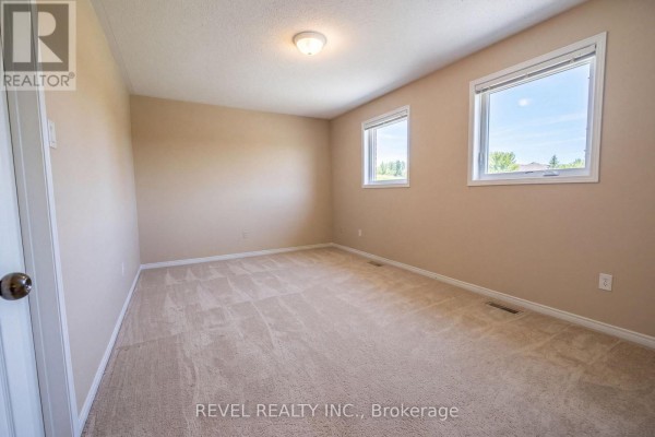 Bedroom with beige carpet and two windows - 176 Towerhill Road Peterborough