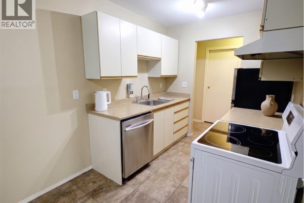 The building lobby with tile floors, beige walls, and a brick accent pillar. - 1760 Brunner Avenue Unit# 218, Kamloops