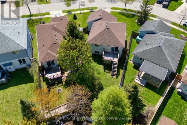 Rear aerial view of the house with a backyard, deck, wooden stairs, and neighboring properties. - 1761 Devos Drive, London North