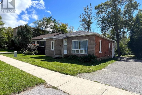 Side exterior of a bungalow showing brick construction and a paved driveway. - 177 Atherley Road, Orillia