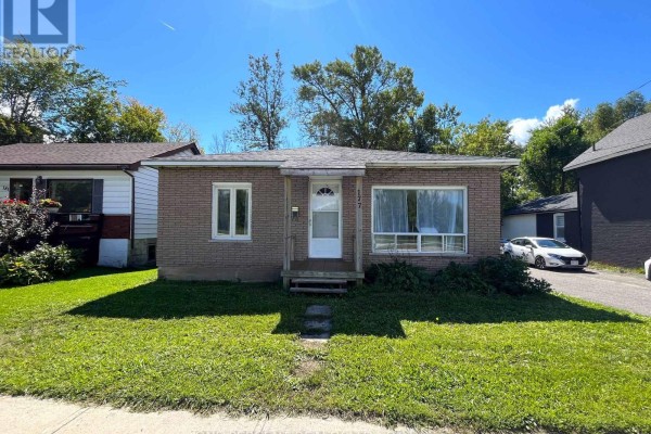 Front view of a modest brick home with green lawn and concrete sidewalk. - 177 Atherley Road, Orillia