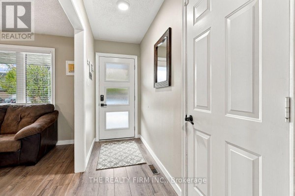 Interior hallway with a white door, a mirror, and a dark brown sofa visible. - 177 Bournemouth Drive, London East