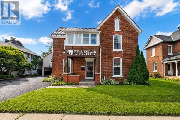 Front of brick building with manicured lawn, walkway, and covered porch. - 177 Dunlop Street W, Barrie