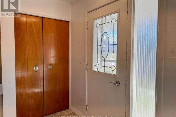 Close-up of the entrance door with a stained-glass panel and silver knob. - 177 Georgina Avenue, Temiskaming Shores