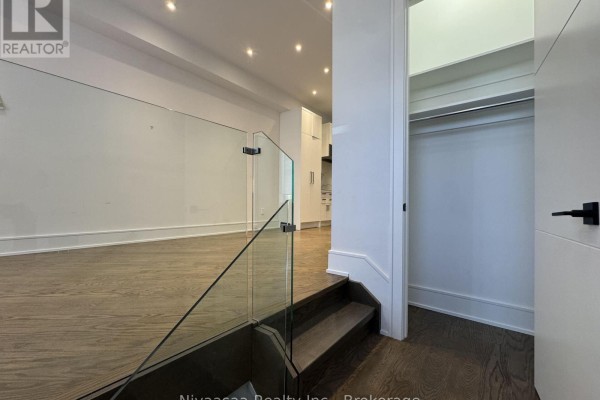Dining area with glass-top table and upholstered chairs, adjacent to a living room area. - 177 Ranleigh Avenue, Toronto