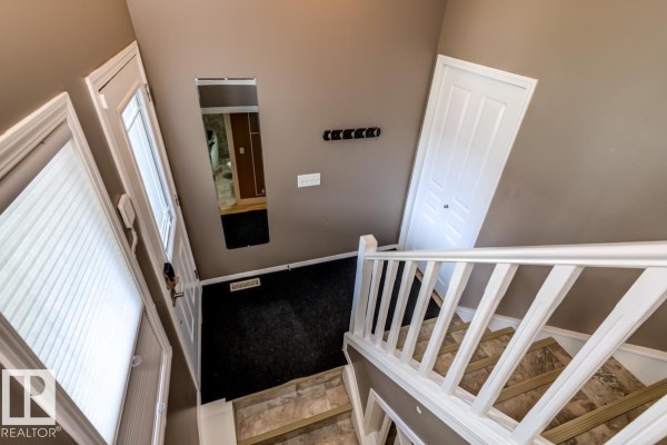 Overhead view of an entryway with a staircase, black carpet, and a mirrored wall. - 17703 90 St Nw, Edmonton