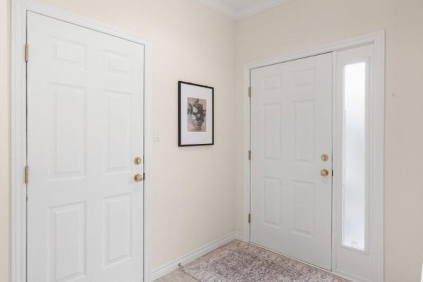 Interior hallway with two white doors, a framed picture, and a patterned rug. - 1777 Ennismore Crescent, London North