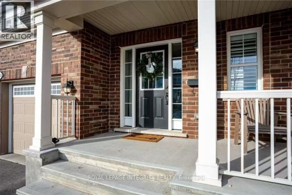 Front door with sidelights and transom window, surrounded by brick facade and porch pillars. - 178 Flowing Creek Circle, Ottawa