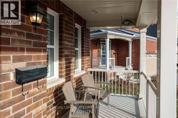 Covered front porch with two wooden chairs, brick walls, and a black mailbox. - 178 Flowing Creek Circle, Ottawa