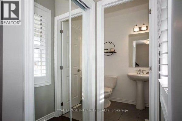 Powder room with pedestal sink, toilet, mirrored medicine cabinet, and plantation shutters on window. - 178 Flowing Creek Circle, Ottawa