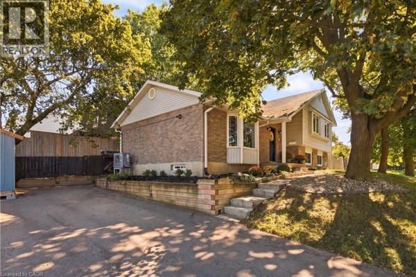 Side view of the house showing the driveway, landscaping, and steps leading to the front entrance. - 178 Laurentian Drive, Kitchener