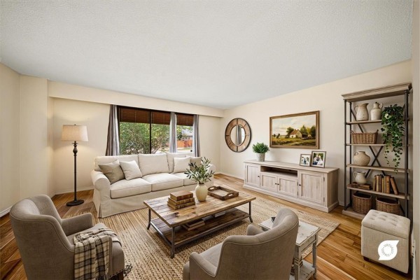 Living room with a cream sofa, two grey armchairs, a wooden coffee table, and a fireplace. - 178 Pentland Street, Winnipeg