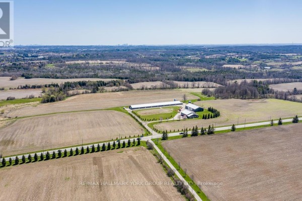 Expansive aerial view of a rural farm property surrounded by tilled fields and scattered trees. - 1783 Lloydtown-aurora Road, King