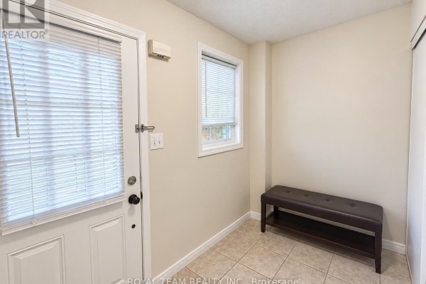 Small entryway with a door, two windows, and a dark brown bench with shoe storage. - 1786 Swan Street, Innisfil