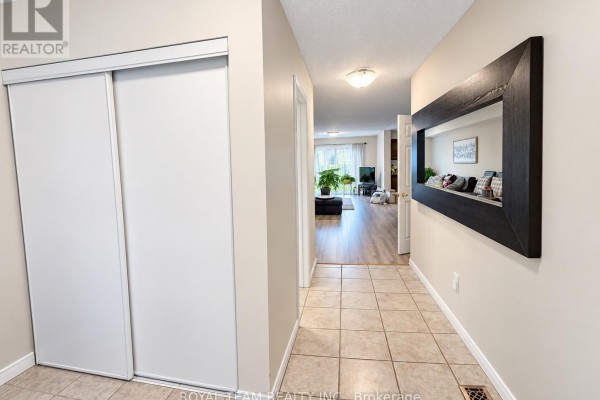 Hallway with tiled floor, white sliding closet doors, and a large dark framed mirror. - 1786 Swan Street, Innisfil