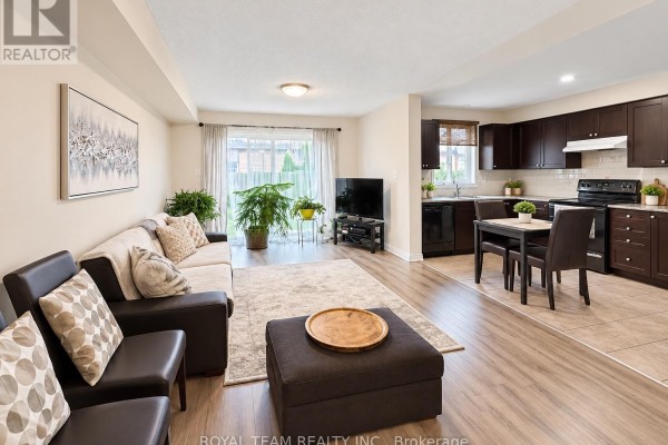 Open concept living room and kitchen with dark cabinets, sofa, and sliding door. - 1786 Swan Street, Innisfil