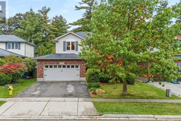 Front exterior of a suburban home with a pitched roof, brick base, and two-car garage under a covered overhang. - 179 Granite Hill Road, Cambridge