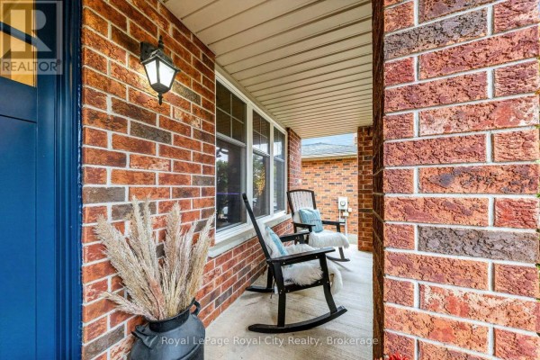 View of a covered front porch featuring two rocking chairs, a lamp, and large decorative reeds in a vase. - 179 Granite Hill Road, Cambridge