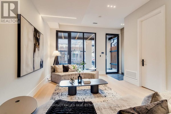 Modern living room with sectional sofa, abstract art & glass doors - 179 Palmerston Avenue Toronto