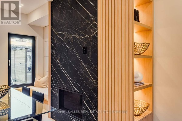Black marble fireplace, wood slat wall, and dining set - 179 Palmerston Avenue Toronto