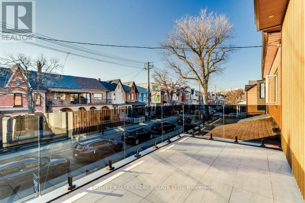 Modern balcony with glass railing overlooking street with houses - 179 Palmerston Avenue Toronto