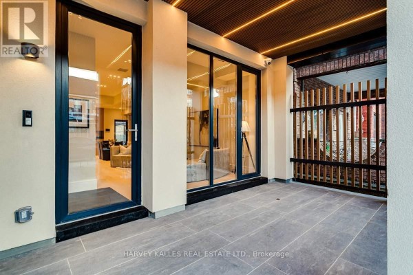 Spacious living room with light wood floors, a fireplace, abstract art, and plush seating. - 179 Palmerston Avenue, Toronto